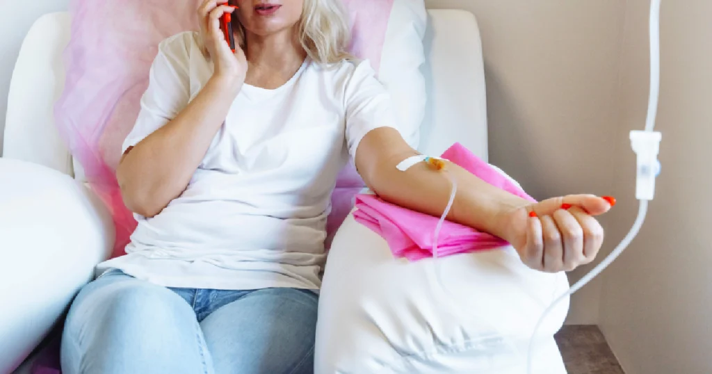 Woman receiving IV therapy while on the phone in a relaxed clinic in Springfield, MO